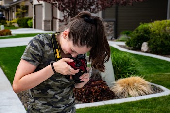 Woman Taking a Picture of Floor Using Nikon Camera