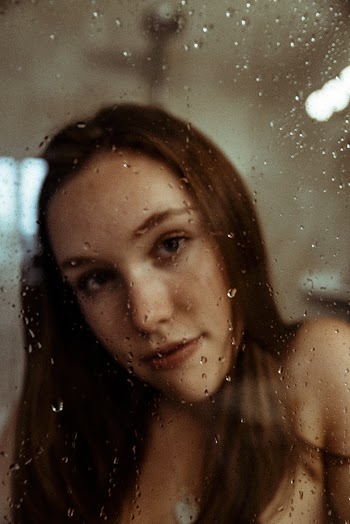 Woman Taking a Selfie in Front of Glass Panel