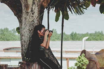 Woman Taking Photo Near to Tree
