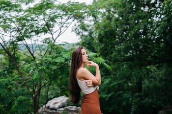 woman taking photo near trees