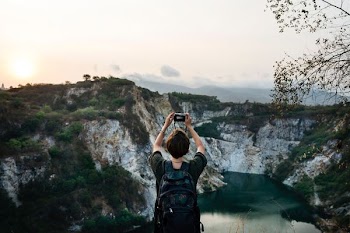 woman taking picture of a mountain