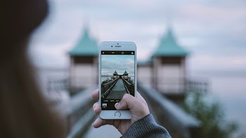 Woman taking picture of interesting architecture on iPhone with out of focus background, Persborg