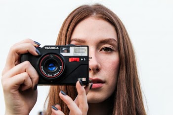 Woman Taking Picture Using Black Yashica Camera