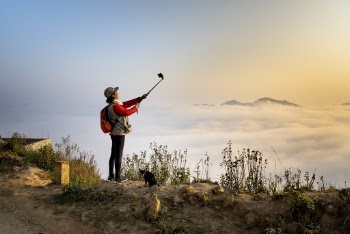 Woman Taking Selfie Viewing  Sea of Clouds
