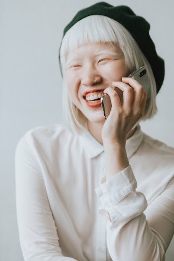 woman talking to phone while laughing