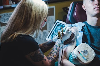 Woman Tattooing Man on His Right Arm