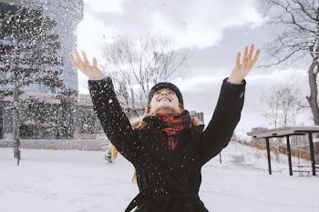 Woman Throwing Snow In Park