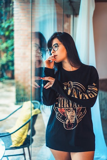 Woman Touches Her Lips While Looking Outside Glass Wall