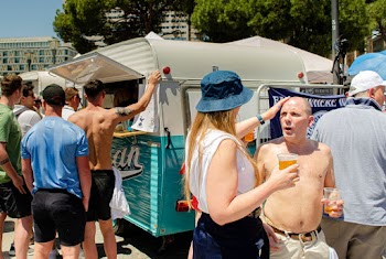Woman Touching Head of Topless Man Holding Cup With Beer