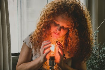 Woman Touching Light Bulb