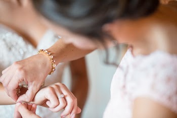Woman Tying Bracelet to Another Woman