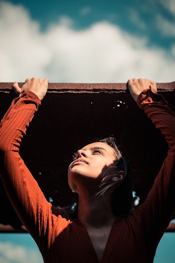 Woman Under Brown Metal Panel With Holes
