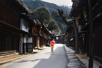 Woman Under Umbrella Walking Through the Street