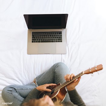 Woman using a laptop while playing ukulele during lockdown | Free  photo - 2329933