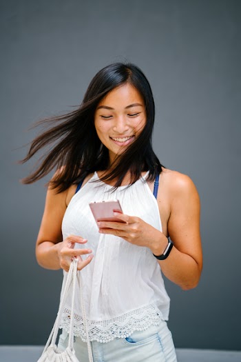 Woman Using A Phone While Carrying A Bag