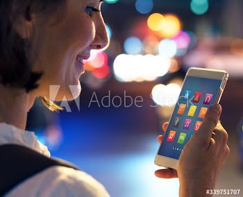 Woman using her phone on the street at night