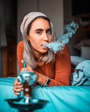 Woman Using Hookah Inside Bedroom