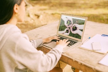 Woman using laptop mockup in nature Free Psd