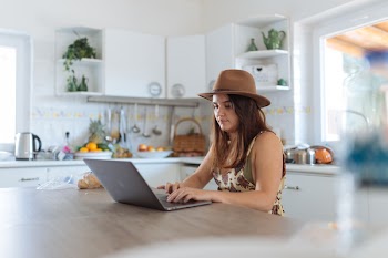 Woman Using Macbook In The Kitchen