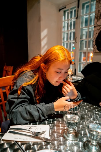 Woman Using Phone Sitting on Chair Beside Table