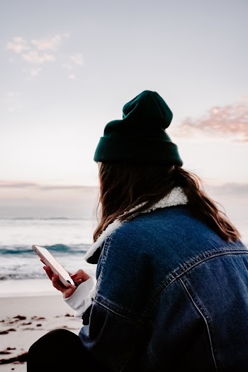 Woman Using Smartphone Beside Body Of Water