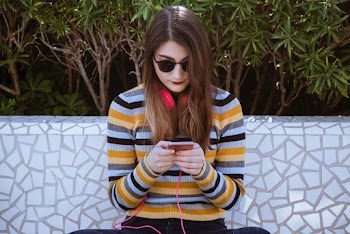 Woman Using Smartphone Near Green Leaf