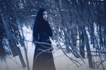 Woman Walking Along Bare Trees 