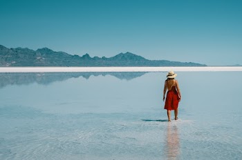 Woman Walking Along Low Tide Beach