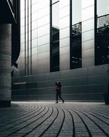 Woman Walking Beside Building