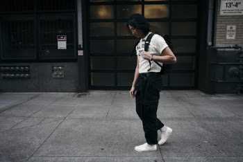 Woman Walking Beside the Building