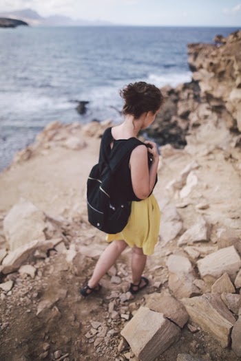 Woman Walking Down Rocky Mountain