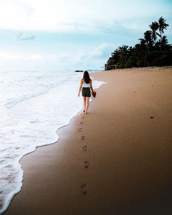woman walking in front of beach