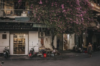 Woman Walking In Front Of White Store