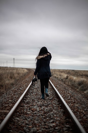Woman Walking in Middle of Railway