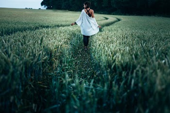Woman Walking in the Rice Plant Field during Daytime