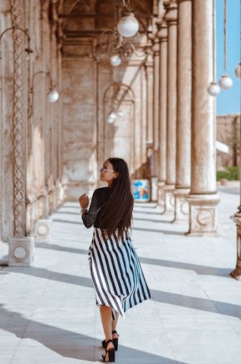 woman walking near concrete pillars