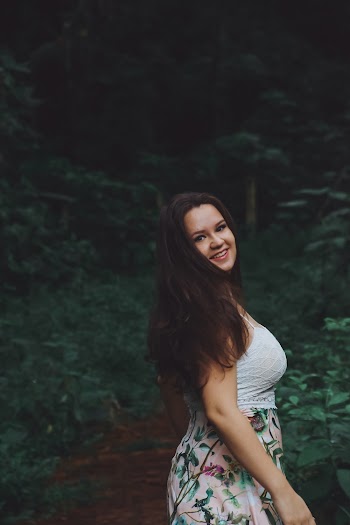 Woman Walking Near Plants While Looking Behind