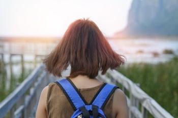 Woman Walking on a Wooden Bridge