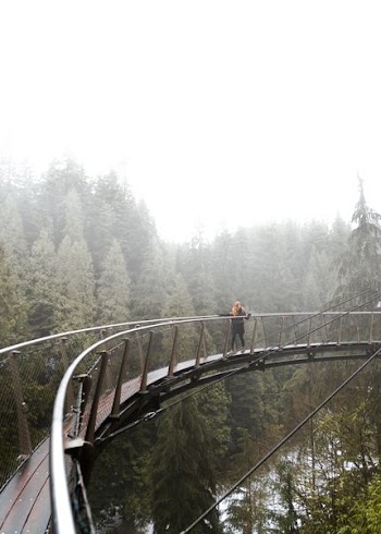 woman walking on brown bridge during daytime