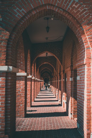 Woman Walking on Concrete Hallway