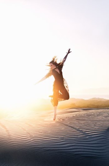 woman walking on desert during sunset
