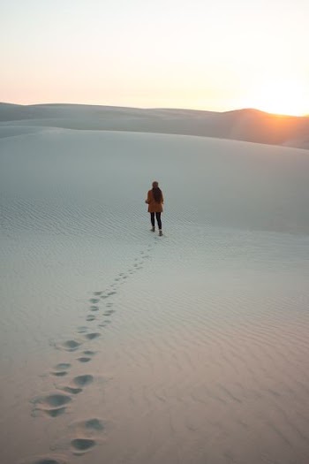 woman walking on dessert during daytime