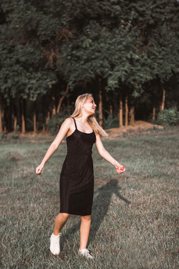 Woman Walking On Grass Field