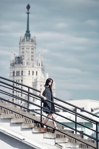 Woman Walking on Gray Concrete Stair Under Gray Sky