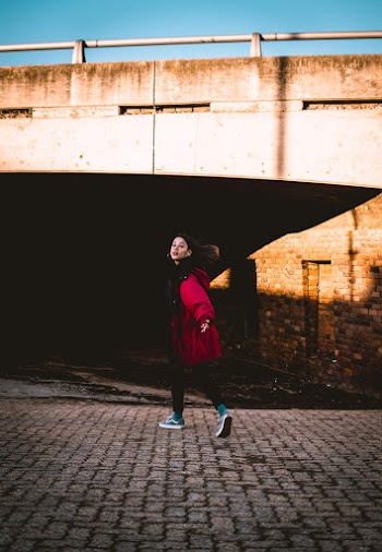 Woman Walking on Pavement While Looking Back