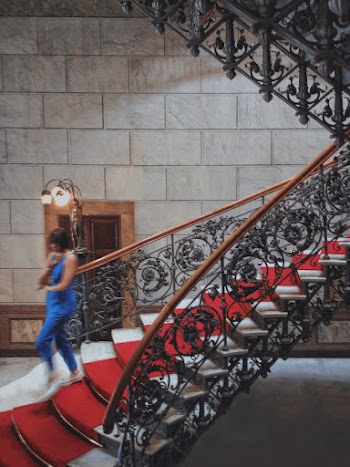 Woman Walking on Red and Black Concrete Staircase