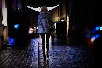 woman walking on street during night