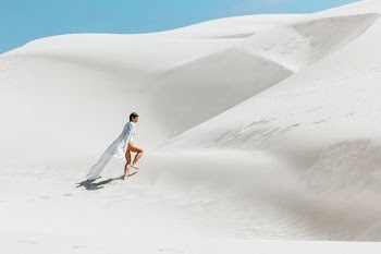 woman walking on white sand dunes