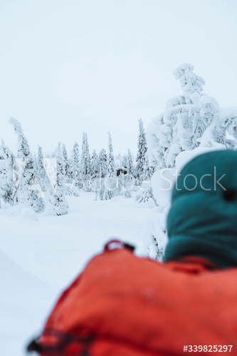Woman walking to a hut in the snowy woods