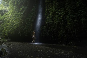 Woman Walking Towards Waterfalls